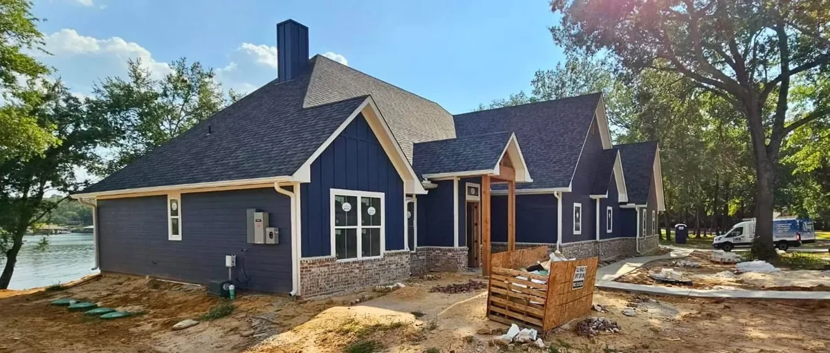 Light-colored gutters following the side roofline of a blue home with a screened porch