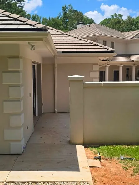 Gutter, fascia and soffit beneath the tiled roof of a cream-colored house