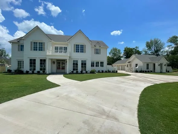 White two-story house with gutters along the eaves and an attached garage